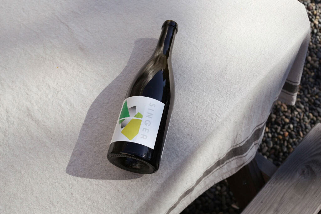 Elegant Singer Wine bottle on outdoor table with natural lighting, perfect for wine tasting and wine gift ideas.